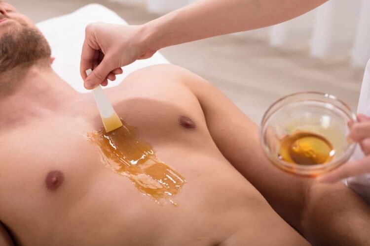 A man is having wax applied to his chest to remove hair during a mens waxing service